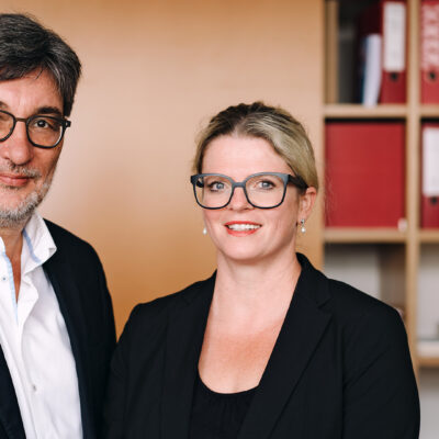 Stefan Hartmann und Susanne Schaper vor einem Ordnerregal